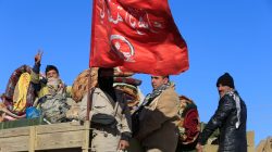 Iraqi army members ride in a military vehicle in Bartila, Iraq