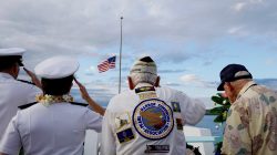 Pearl Harbor survivors Delton Walling (C), Gilbert Meyer (R) and U.S. Navy Admiral Margaret Kibben salute during a ceremony honoring the sailors of the USS Utah at the memorial on Ford Island at Pearl Harbor in Honolulu, Hawaii