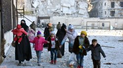Civilians, who evacuated the eastern districts of Aleppo, carry their belongings as they arrive in a government held area of Aleppo, Syria,