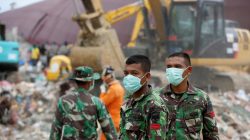 Indonesian soldiers help to secure an area where rescue and salvage operations take place at a collapsed building following this week's strong earthquake in Meureudu, Pidie Jaya, Aceh province, Indonesia