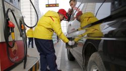 A gas station attendant pumps fuel into a customer's car at PetroChina's petrol station in Beijing, China,