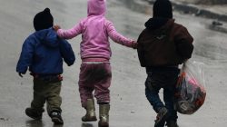 Children walk together as they flee deeper into the remaining rebel-held areas of Aleppo, Syria
