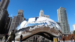 People walk by snow-covered statue