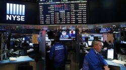 A trader works on the floor of the New York Stock Exchange (NYSE) as a television screen displays coverage of U.S. Federal Reserve Chairman Janet Yellen shortly after the announcement that the U.S. Federal Reserve will hike interest rates, in New York, U.S.,