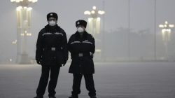 Policemen wear protective masks at the Tiananmen Square on an extremely polluted day as hazardous, choking smog continues to blanket Beijing, China