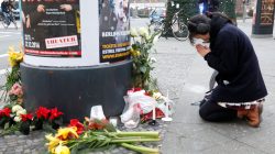 A woman prays near the area where a truck which ploughed into a crowded Christmas market in the German capital last night in Berlin.