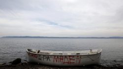 A wooden boat, used by migrants and refugees, is abandoned at a beach on the Greek island of Lesbos November, 2015. The writing on the boat reads "Aegean zero hour"