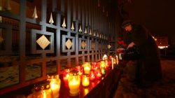 A woman lays flowers in memory of passengers and crew members of Russian military Tu-154 plane, which crashed into the Black Sea, at the Russian embassy in Minsk