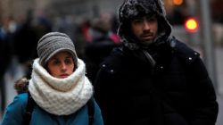 People walk along Wall Street ahead of a cold weather system across the region in Manhattan, New York City, U.S.,