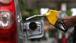 A worker fills a tank with subsidized fuel at a fuel station in Jakarta