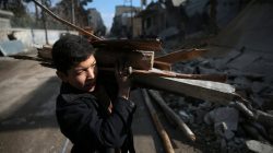 A boy collects firewood in the rebel held besieged city of Douma, in the eastern Damascus