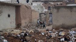 Children play near rubble of damaged buildings in al-Rai town, northern Aleppo countryside, Syria