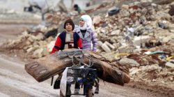 Samah, 11, and her brother, Ibrahim, transport their salvaged belongings from their damaged house in Doudyan village in northern Aleppo
