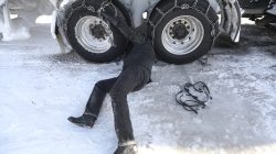 Semi truck driver removes chains from truck