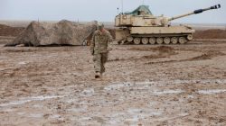 US Soldier walks in front of tank in Iraq
