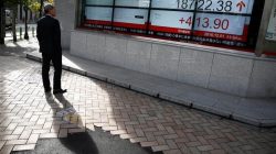 man looks at stock board