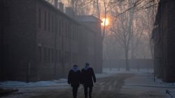 Survivors walk in remains of Nazi German concentration camps