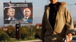 woman passes billboard of Trump and Putin together