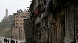People walk past damaged shops in Aleppo Syria