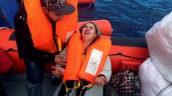 migrants woman praying after rescue