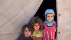 girls stand at the entrace of tent in yemen