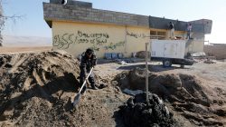Workers repair a house after it was damaged during clashes in the town of Basheeqa, Iraq, February 8, 2017.