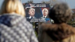 A billboard showing a pictures of US president-elect Donald Trump and Russian President Vladimir Putin is seen through pedestrians in Danilovgrad, Montenegro,