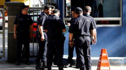 Police officers gather outside of Malaysia morgue