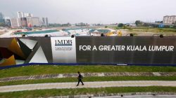 Man walks past Malaysia billboard at airport