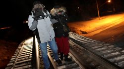 Refugees walk along railway tracks from the United States to enter Canada at Emerson, Manitoba, Canada, February 26, 2017. REUTERS/Lyle Stafford