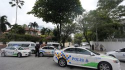 Police cars form a roadblock outside the sealed off North Korea embassy in Kuala Lumpur, Malaysia