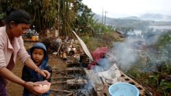 Refugee who fled fighting in neighbouring Myanmar washes dishes outside the house of a relative in the village of Baiyan near Nansan in the Yunnan province, China
