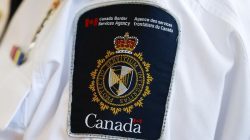 A Canada Border Services Agency (CBSA) logo is seen on a worker during a tour of the Infield Terminal at Toronto Pearson International Airport in Mississauga, December 8, 2015. REUTERS/Mark Blinch