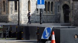 An armed police officer guards an entrance to Windsor Castle, near to where security barriers have been placed. REUTERS/Peter Nicholls