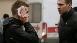 An injured person stands outside Sennaya Ploshchad metro station, following explosions in two train carriages at metro stations in St. Petersburg.