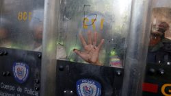 Riot police officers takes cover with their shields during a protest against Venezuela's President Nicolas Maduro's government in Caracas. REUTERS/Carlos Garcia Rawlins