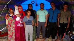 Displaced Iraqi woman Farah Taha, 60, poses for a photograph with her three sons, her daughter-in-law, her six-month-old grandchild as well as the brother and sister of her daughter-in-law, in the family tent in Hammam al-Alil camp south of Mosul, Iraq March 29, 2017. Taha says she has been unable to find any work to support her family since fleeing their Mosul home. REUTERS/Suhaib Salem