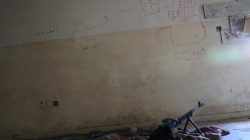 A machine gun is seen on the floor next to a map drawn to show distances, on the wall of a sniper's nest in a building controlled by Iraqi forces fighting the Islamic State in Mosul, Iraq, April 6, 2017. REUTERS/Andres Martinez Casares