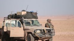 A U.S. fighter stands near a military vehicle, north of Raqqa city, Syria