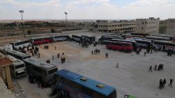 People, who were evacuated from the two rebel-besieged Shi'ite villages of al-Foua and Kefraya, stand near buses at insurgent-held al-Rashideen, Aleppo province, Syria April 19, 2017. REUTERS/Ammar Abdullah