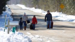 A family that says they are from Colombia walks down Roxham Road toward the U.S.-Canada border leading into Hemmingford, Quebec, Canada March 26, 2017. REUTERS/Christinne Muschi