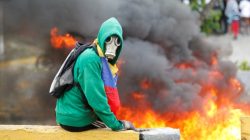 FILE PHOTO: Demonstrator sits next to a fire barricade on a street during a rally against Venezuela's President Nicolas Maduro in Caracas, Venezuela April 24, 2017. REUTERS/Christian Veron/File Photo