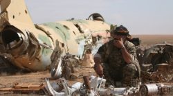 A Syrian Democratic Forces (SDF) fighter rests near destroyed airplane parts inside Tabqa military airport after taking control of it from Islamic State fighters, west of Raqqa city, Syria April 9, 2017. REUTERS/Rodi Said