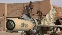 Syrian Democratic Forces fighters gesture while posing on a damaged airplane inside Tabqa military airport after taking control of it from Islamic State fighters, west of Raqqa city, Syria ,