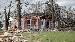 Homeowners clean up debris after a tornado hit the town of Emory, Texas.
