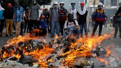 Opposition supporters stand in front of a fire during clashes with riot police at a rally against President Nicolas Maduro in Caracas, Venezuela May 3, 2017. REUTERS/Carlos Garcia Rawlins