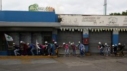 Volunteers, members of a primary care response team, walk together as demonstrators clash with police during a rally against Venezuela's President Nicolas Maduro in Caracas, Venezuela. REUTERS/Marco Bello