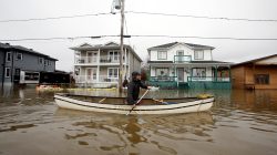 A man paddles a canoe in a flooded residential area in Gatineau, Quebec, Canada