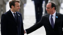 Outgoing French President Francois Hollande (R) reaches out to touch President-elect Emmanuel Macron, as they attend a ceremony to mark the end of World War II at the Tomb of the Unknown Soldier at the Arc de Triomphe in Paris, France,