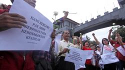 Supporters of former Jakarta governor Basuki Tjahaja Purnama hold a small rally outside the gate of the Mobile Police Brigade or Brimob headquarters where he is being detained, in Depok, south of Jakarta, Indonesia May 10, 2017 in this photo taken by Antara Foto. Antara Foto/Yulius Satria Wijaya/ via REUTERS
